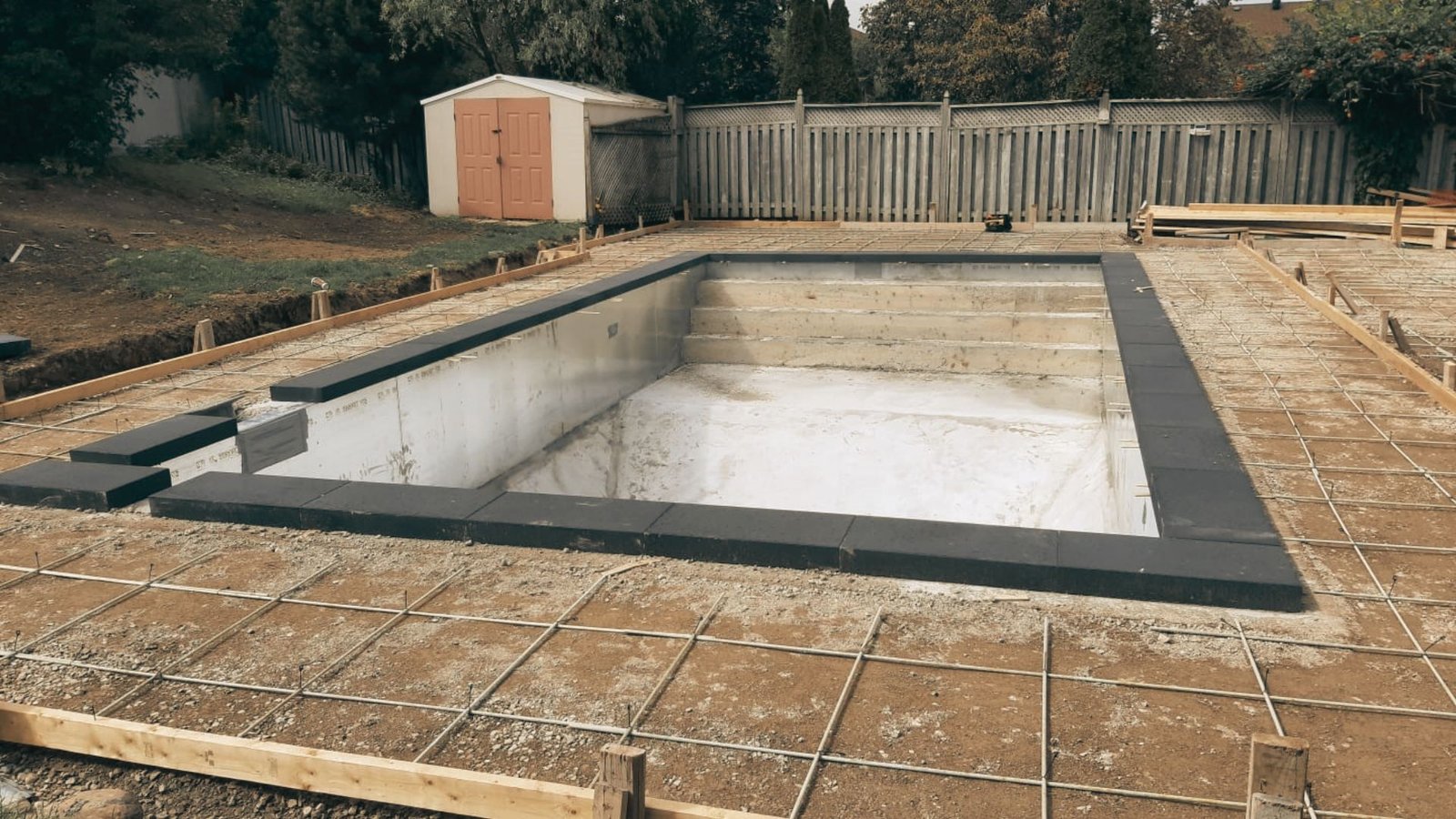 Decking and landscaping installation around a swimming pool.