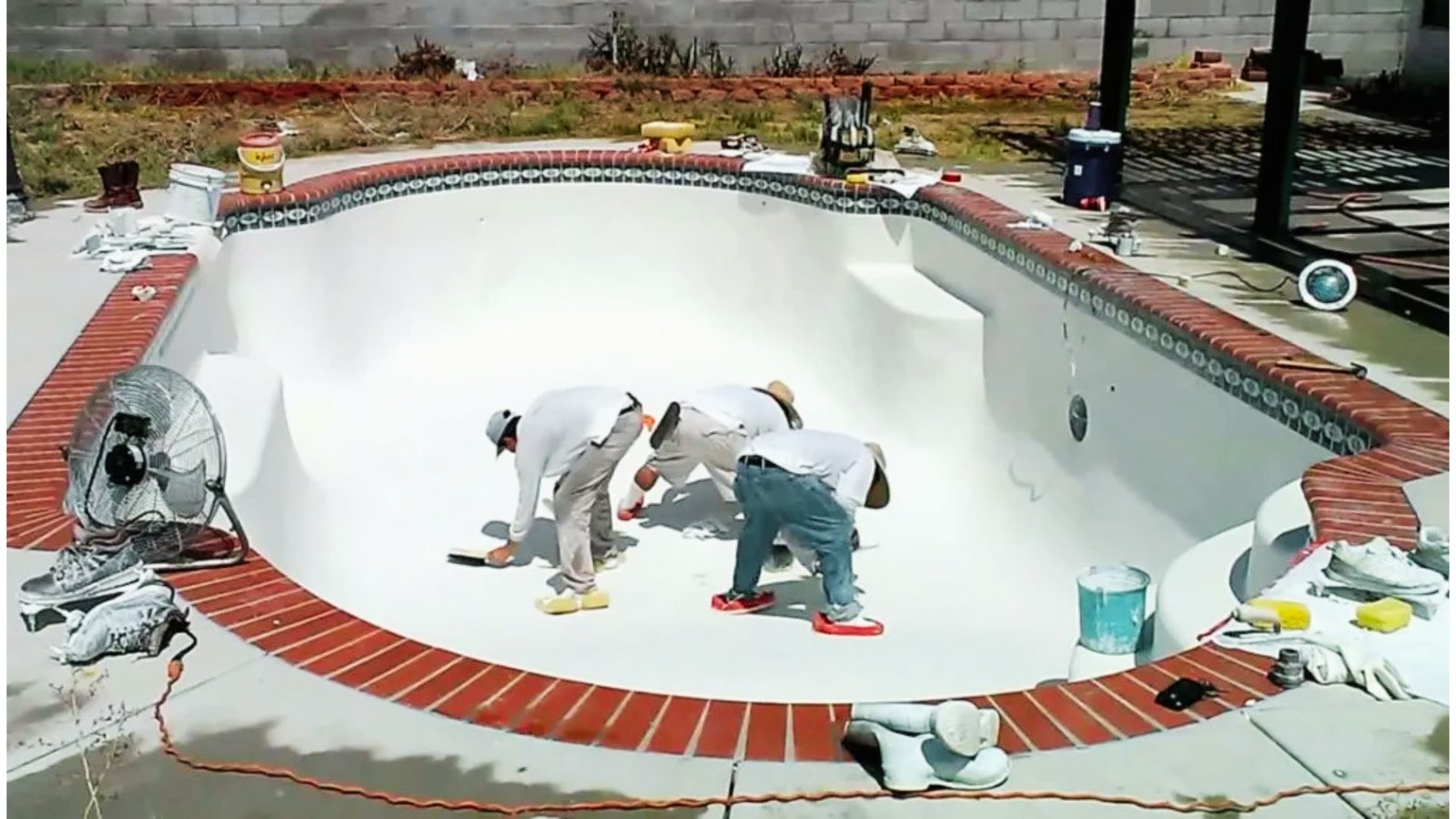 Applying interior finish to an inground swimming pool.