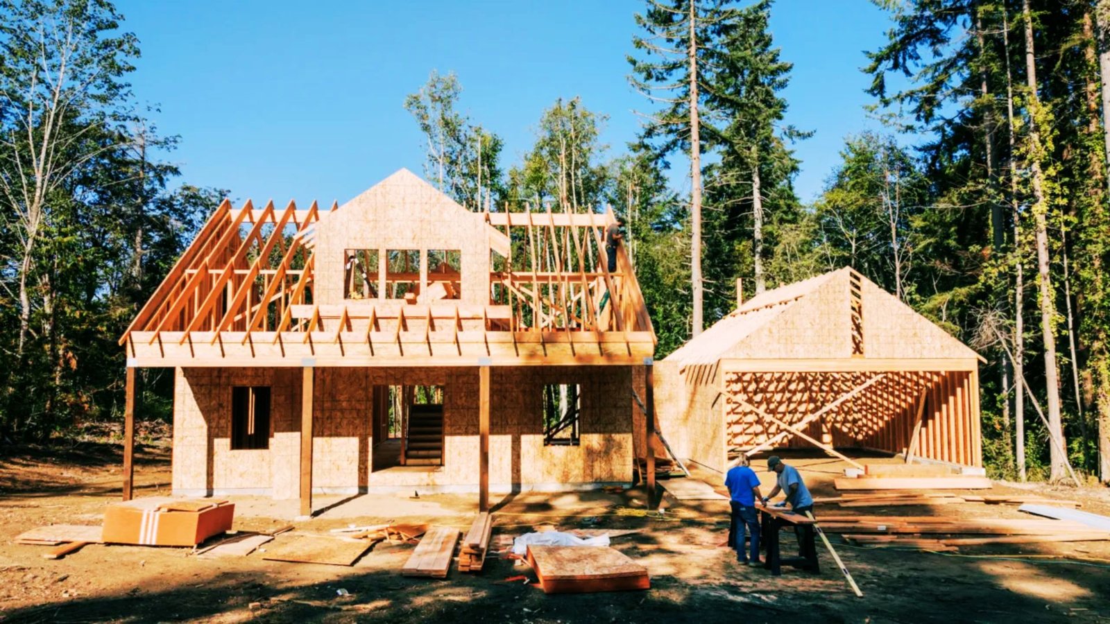 Homeowner reviewing construction costs and blueprints for building a house on owned land.