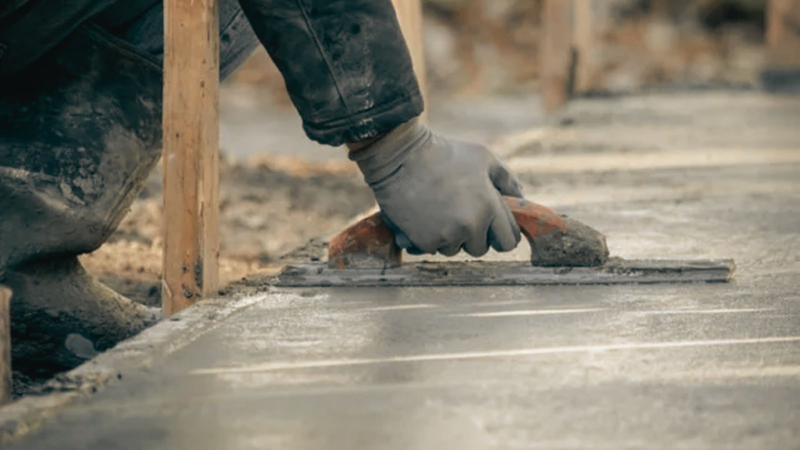 Fresh concrete slab being finished and cured after pouring.